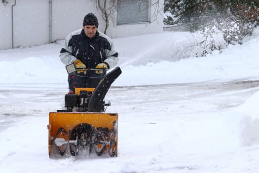 Snow clearing in case of heavy snowfall. A man clears snow with a snow blower