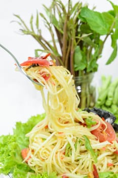 Closeup of Green Papaya salad or Somtum with pickled crab on white background. Famous Thai spicy street food in Thailand