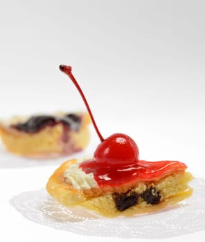 Piece of cherry cheese pie with cherry and jam on white background
