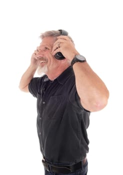 A close-up image of a middle age man with gray hair and beard putting.on his head phone listening to music, isolated for white background.