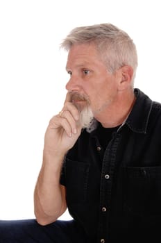 A gray hared middle aged man sitting isolated for white background with.his hand on chin, looking away, isolated for white background.
