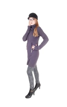 A beautiful brunette woman standing in a winter coat and hat,.with glasses in profile, isolated for white background.