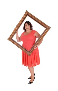 An heavy woman in a red dress standing isolated for white background.holding a old picture frame looking trough.