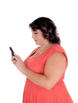A lovely forties years woman in a red dress standing in profile and.dealich on her smart phone, isolated for white background.