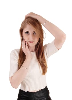 A beautiful young woman in a beige sweater and long brunette hair.holding her hands on her face, isolated for white background.