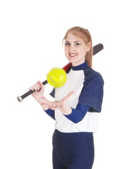A smiling young woman standing in her blue softball uniform playing.with the yellow ball holding her bat, isolated for white background.