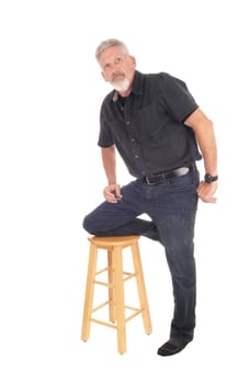 A gray hared middle aged man kneeling isolated for white background .on a bar chair, with a gray bead and hair.