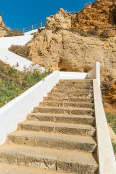 Stairs to a pool of natural sea water between sandstone cliffs at Algar Seco. Carvoeiro Algarve Portugal.