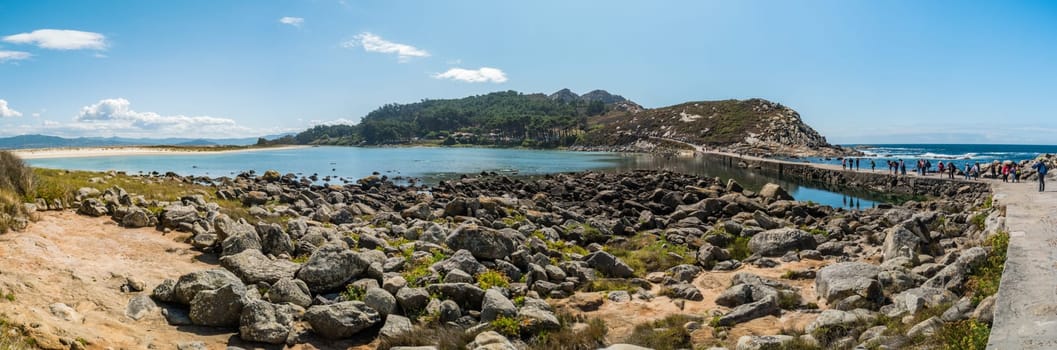 ISLAS CIES, SPAIN - CIRCA SEPTEMBER 2017: Unidentified visitors cross the courseway between the Cies Islands in the Atlantic Ocean, included in the Atlantic Islands of Galicia National Park.