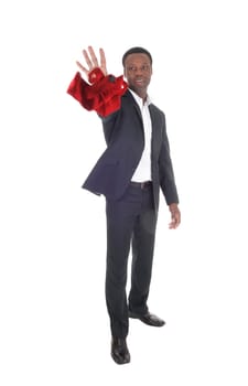 A tall handsome African American man standing in a dark suit and .throwing away his red tie, smiling, isolated for white background.