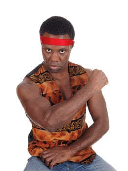 A handsome African American man sitting in a vest making a fist and .looking angry, isolated for white background.