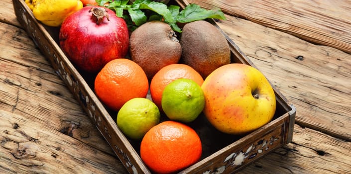 Box with apple, tangerine, lime and pomegranate.Healthy lifestyle concept