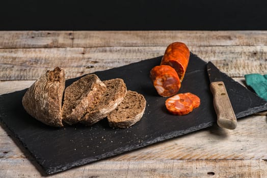 Malt loaf bread and chorizo slices on table.