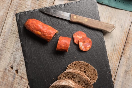 Malt loaf bread and chorizo slices on table.