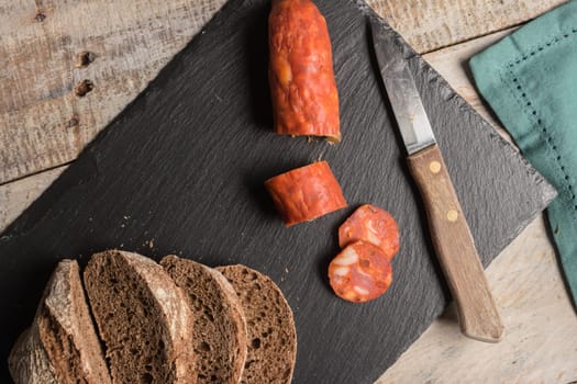 Malt loaf bread and chorizo slices on table.