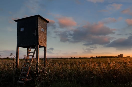 Wooden hunter tower high seat. Raised shed hunting.
