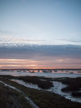 sun set sky dramatic clouds sea front beach harbor marina boats moored landscape  west mersea, essex, england, uk