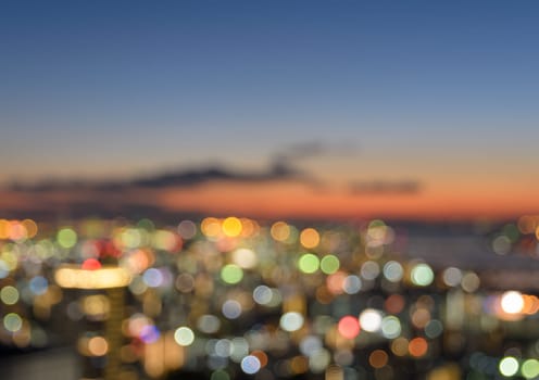 Colorful blurred skyline with city bokeh lights illuminated at sunset
