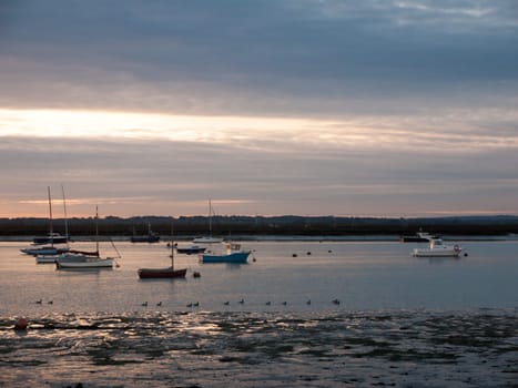 sun set sky dramatic clouds sea front beach harbor marina boats moored landscape  west mersea, essex, england, uk