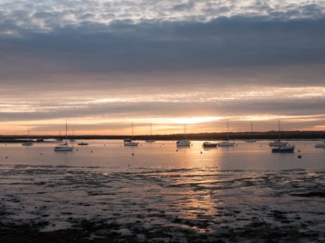 sun set sky dramatic clouds sea front beach harbor marina boats moored landscape  west mersea, essex, england, uk