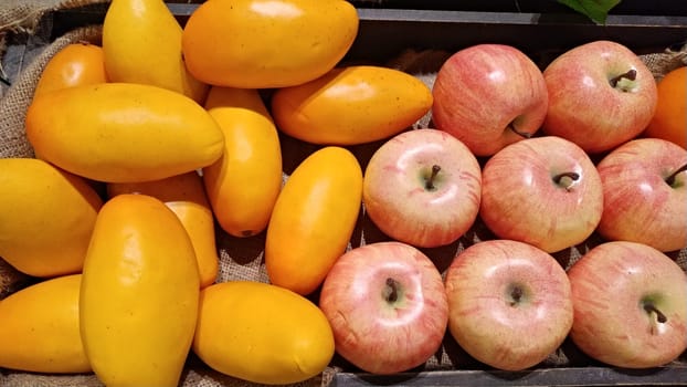 The ripe juicy papaya cut in half on wood kitchen table with citrus fruits apples knife top view closeup