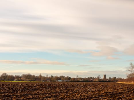 brown ploughed agricultural field outside farm landscape sky ground dirt tree  essex  england  uk