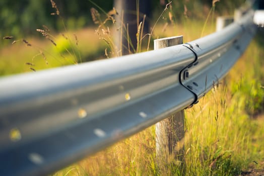 Gard rail on country side road in Europe, Norway. Grass in background, detail view