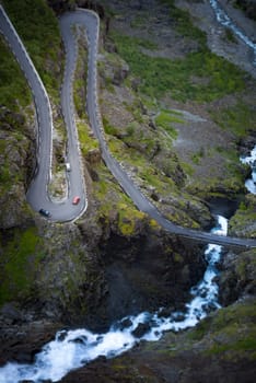 Trollstigen mountain road. Bridge over river with waterfall. Cars on serpentine. Auto travel in Norway, Europe, Scandinavia