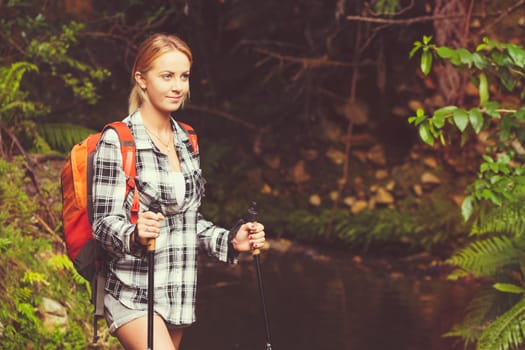 Pretty blond girl hiking with backpack