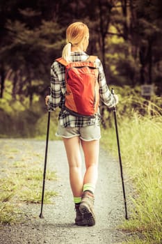 Young blond woman hiking on path