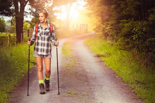 Young woman hiking on country road