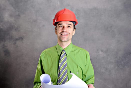 young architect in green shirt with plan and red helmet