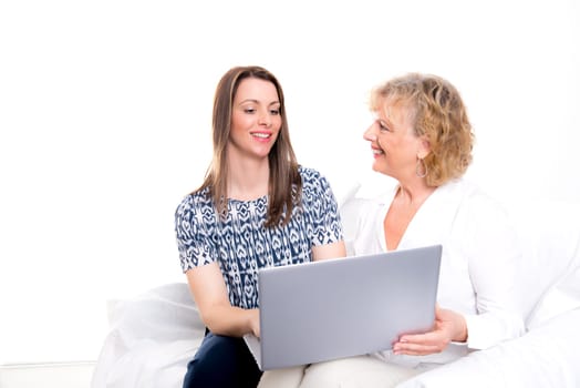 young woman and her mother with laptop in front of white background