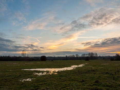 empty wet grass field low light sunset landscape dedham plain empty no people dramatic sky trees  essex  england  uk