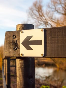 black and white direction way sign left black wooden post outside close up  essex  england  uk