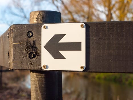 black and white direction way sign left black wooden post outside close up  essex  england  uk