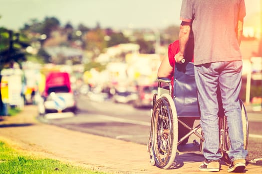 Man pushing woman in wheelchair