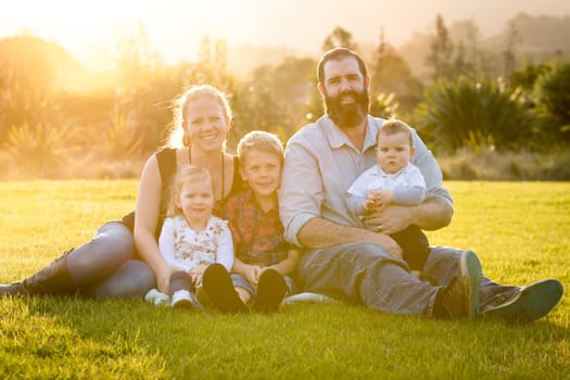 Smiling family of five at sunset