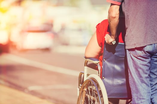 Man pushing woman in wheelchair