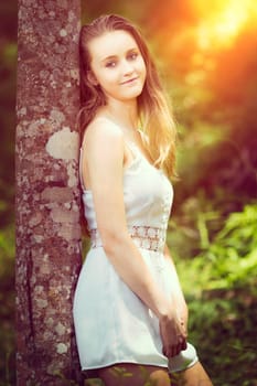 Beautiful teen girl standing by tree