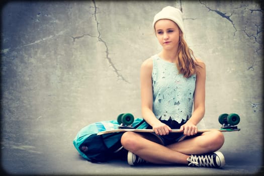 Teenage skater girl holding skateboard