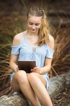 Blonde teenage girl using tablet device