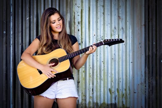 Beautiful smiling girl playing guitar