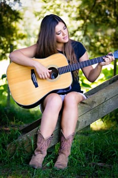 Beautiful girl playing guitar outside