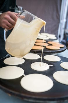 Men preparing delicious pancakes on the street food market in Bergen, Norway