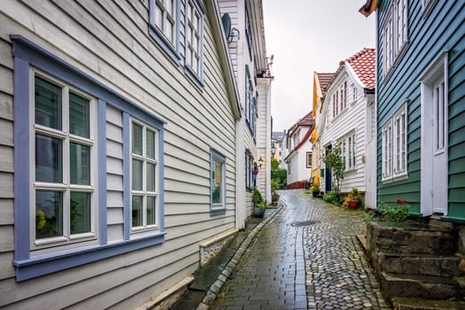 Narrow cobble stoned streets between traditional old colorful houses in the old part of Bergen town, Norway