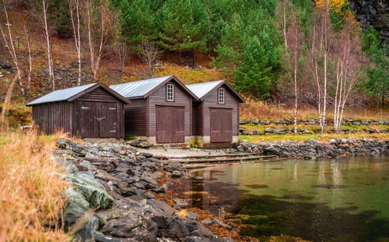 Three wooden huts on the shore of a fiord in a small village Flam, Norway