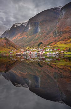 Small homes on the shore of a fjord photographed from a Fjords sightseeing cruise boat in autumn, Norway