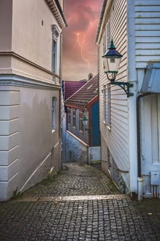 Narrow cobble stoned streets between old white traditional houses in the old part of Bergen town, Norway
