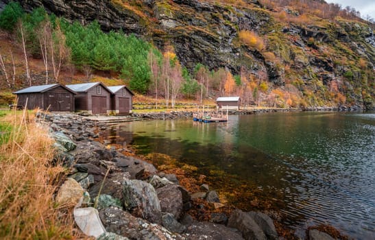 Three wooden huts on the shore of a fiord in a small village Flam, Norway